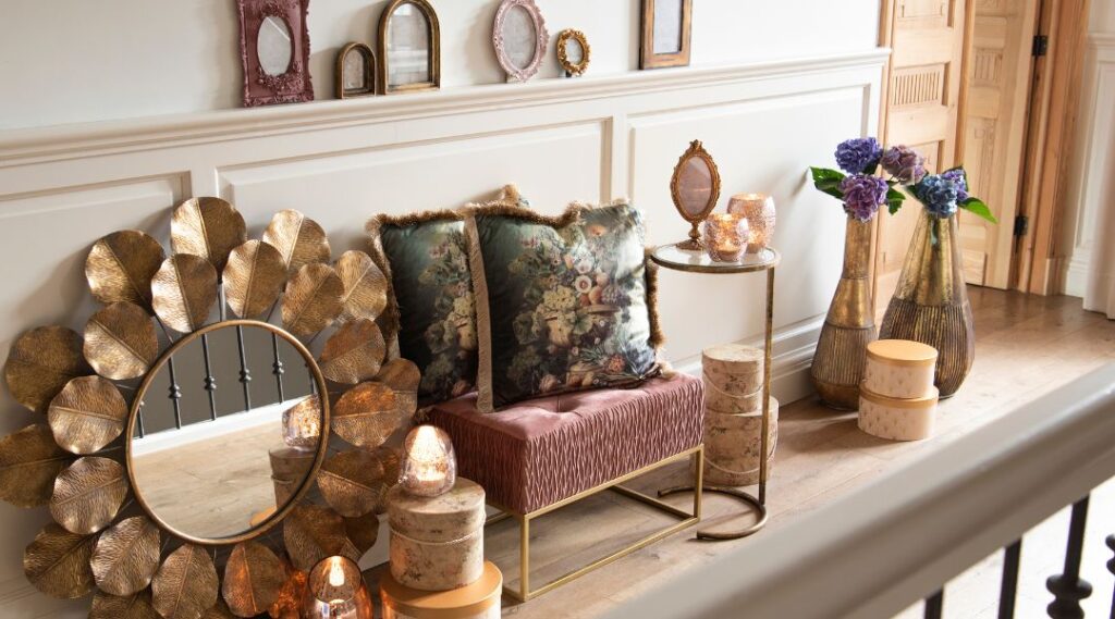 roze fauteuil met een gouden spiegel ernaast. Ruimte is aangekleed met roze en gouden interieur decoraties.